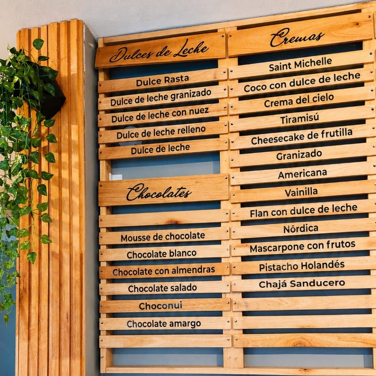 El panel de sabores en listones de madera: dulces de leche, chocolates y cremas, con nombres como Choconui, Chajá Sanducero y Pistacho Holandés