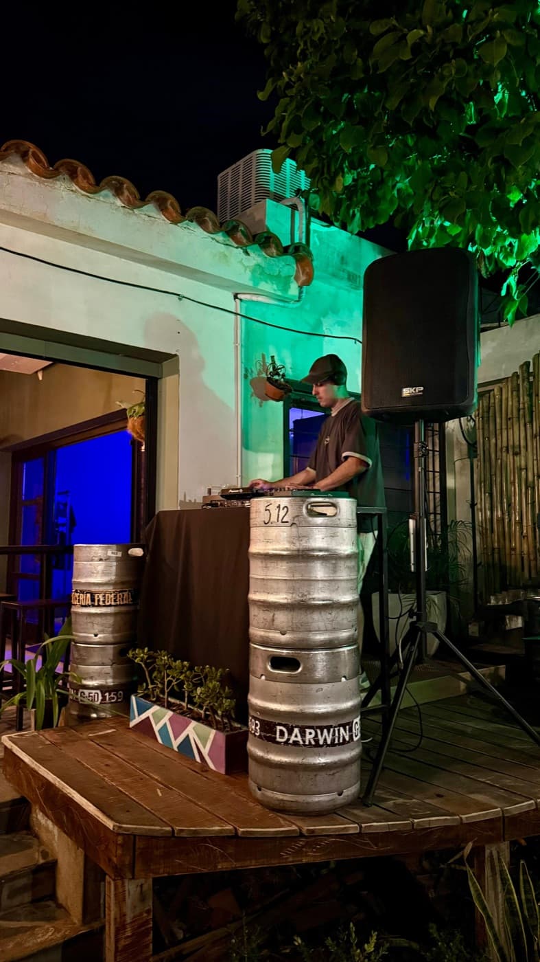 El patio de Pausen con un DJ tocando entre barriles de cerveza
