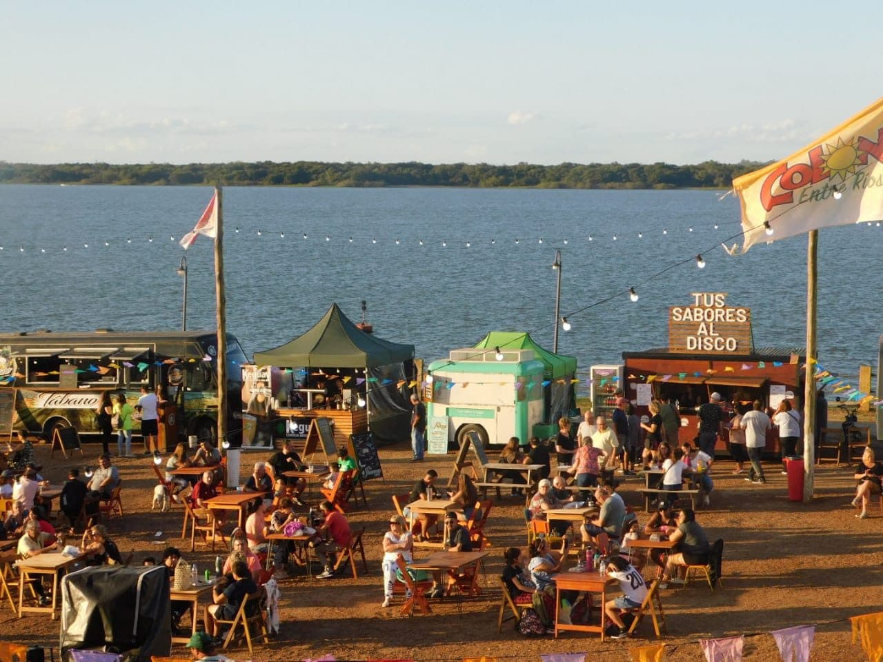 Feria gastronómica con food trucks sobre la costanera de Colón, Entre Ríos, al atardecer