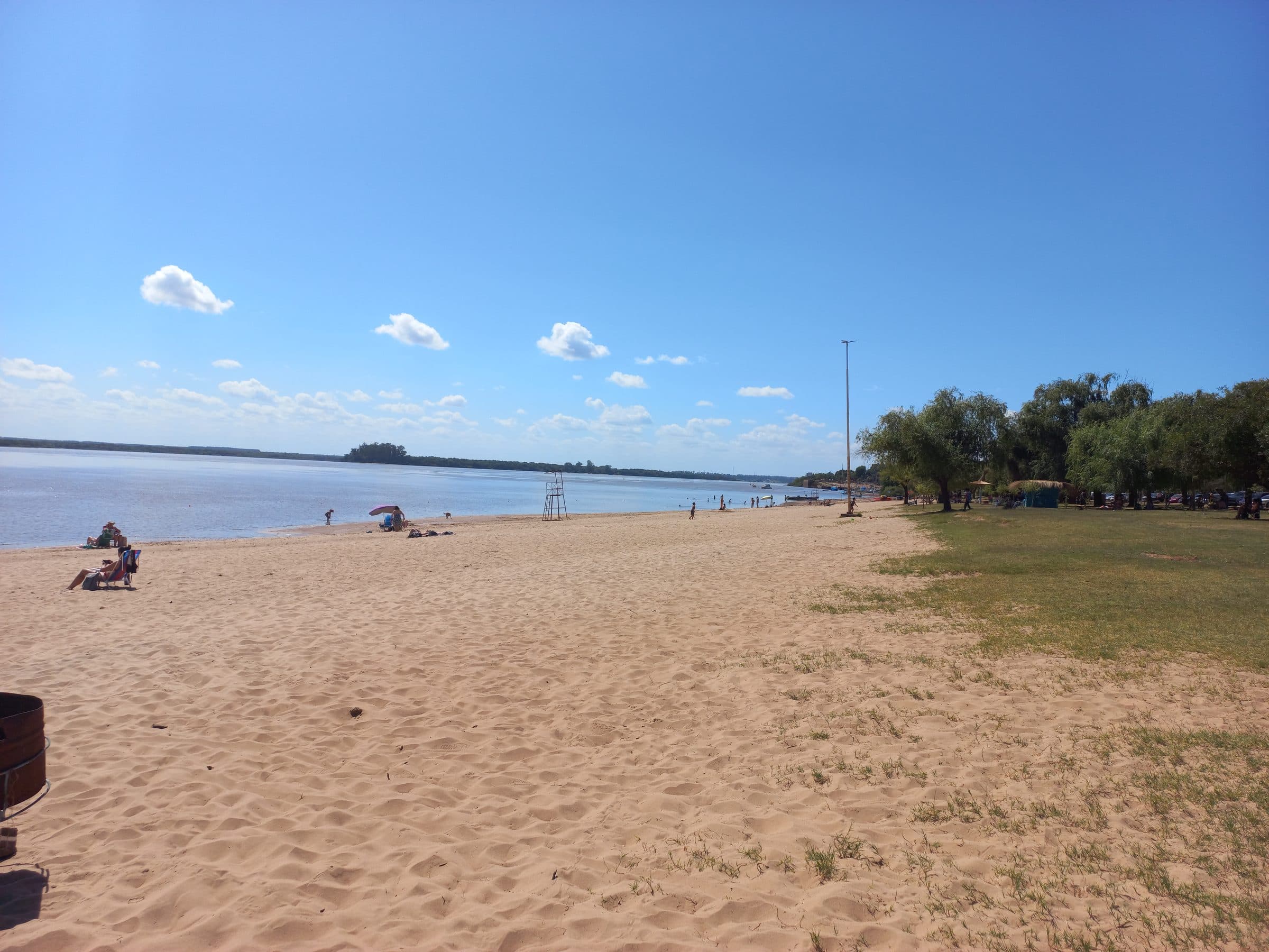 Playa de arena y arboleda sobre el río Uruguay en Colón, Entre Ríos, con puesto de guardavidas